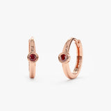 Pair of handmade solid 14k rose gold huggies with single red garnet bezel stone
