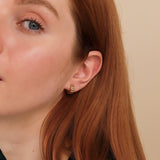 Model wears dainty gold grosgrain huggie earring gift for her